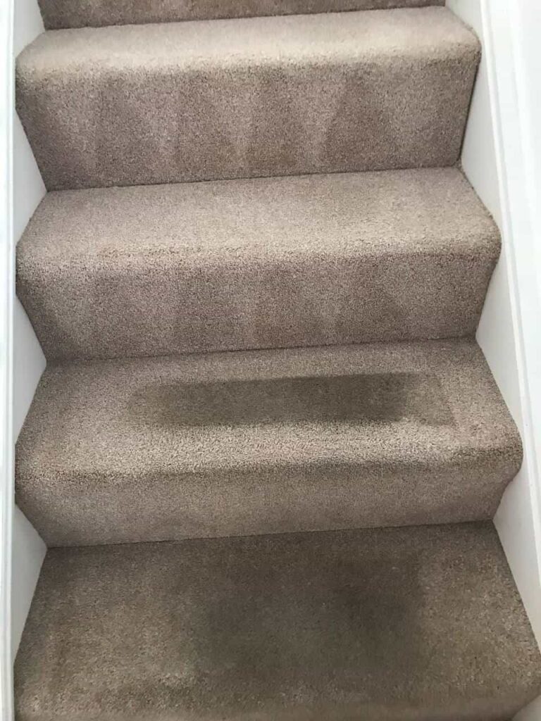 this is a photo of a staircase with beige carpets that is in the process of being cleaned works carried out by Chessington Carpet Cleaning