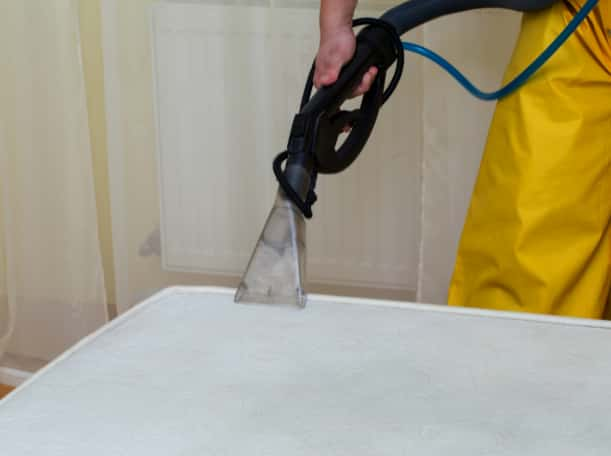 This is a photo of a man steam cleaning a dirty mattress works carried out by Chessington Carpet Cleaning